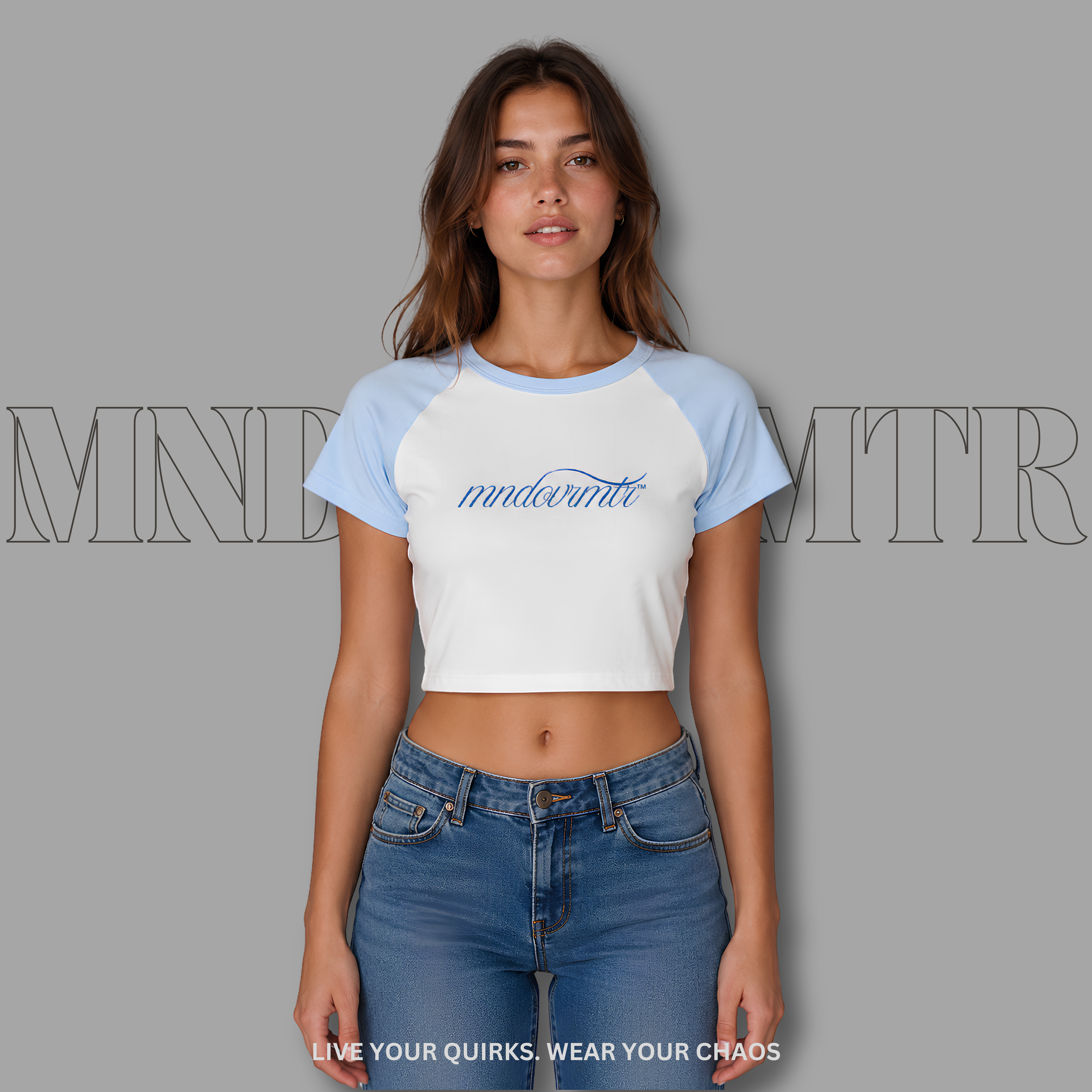 Woman wearing a white and blue baseball shirt with 'mndovrmtr™' branding on a gray background