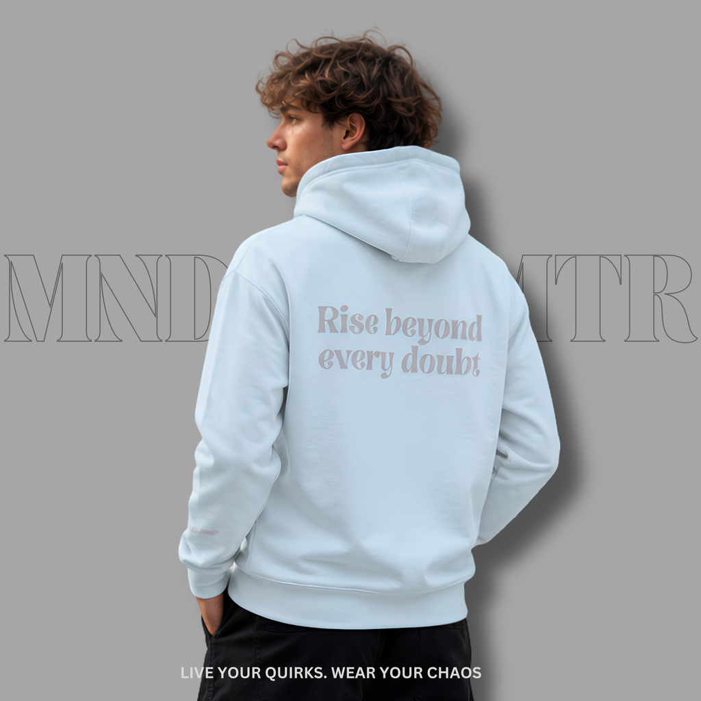 A man shown from the back wearing a light blue , oversized, fleece, hoodie with the text 'Rise beyond every doubt' printed in gray on the back, set against a solid gray background.