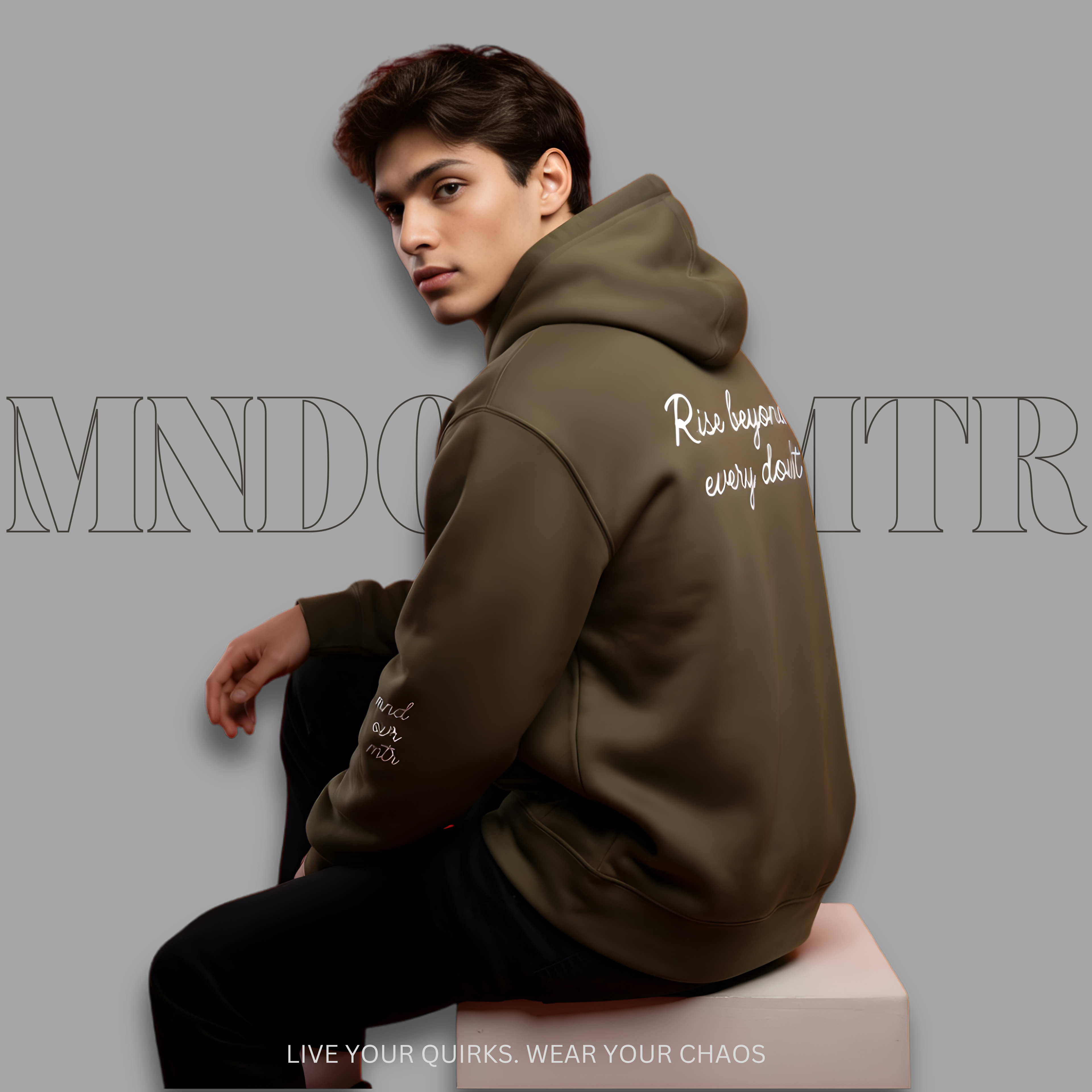 MNDOVRMTR oversized, military green, fleece hoodie, worn by a fine male model, casually sitting. 